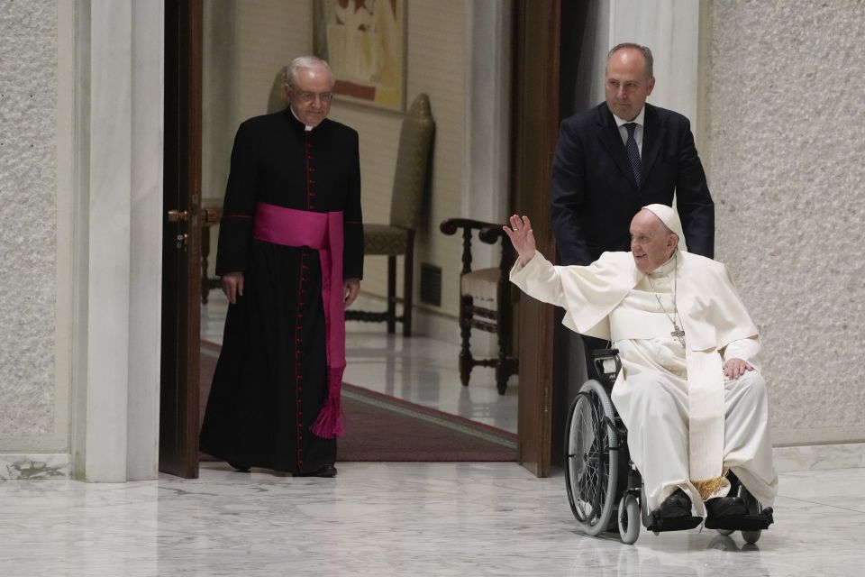 Pope Francis arrives in a wheel chair in the Paul VI hall to attend an audience with pilgrims from central Italy at the Vatican, Saturday, May 14, 2022. (AP Photo/Gregorio Borgia) Pope Francis arrives in a wheel chair in the Paul VI hall to attend an audience with pilgrims from central Italy at the Vatican, Saturday, May 14, 2022. (AP Photo/Gregorio Borgia)