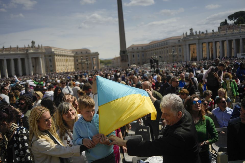 People display a Ukrainian flag as Pope Francis delivers the traditional "urbi et orbi" ("to the city and the world") blessing at the end of the Easter Sunday Mass he led in St. Peter's Square at the Vatican April 17. (AP/Alessandra Tarantino)