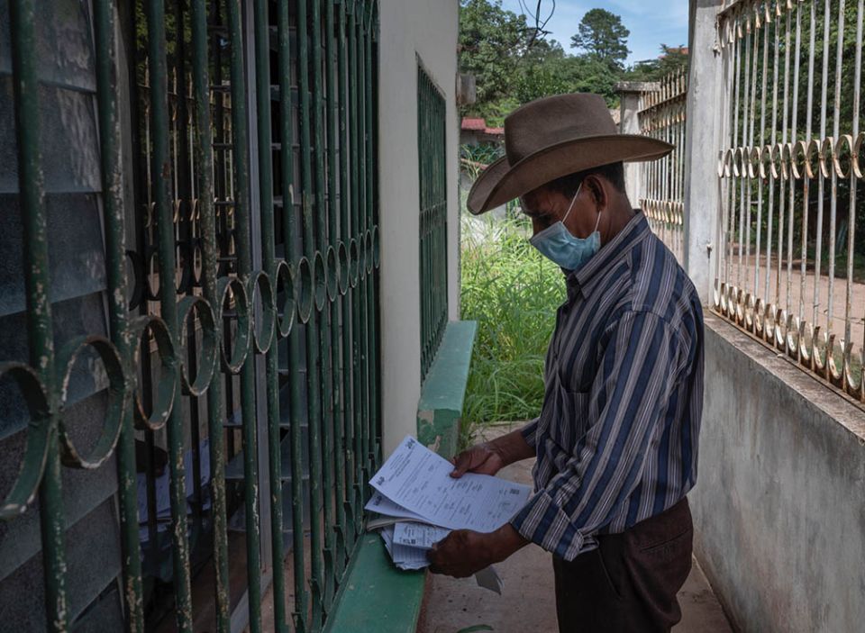 A resident of Yorito prepares his voter registration forms ahead of elections in November.