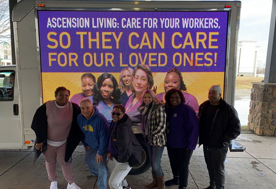 Ascension Living workers at Our Lady of Peace pose in front of a billboard. (Courtesy of 1199SEIU United Healthcare Workers East) Ascension Living workers at Our Lady of Peace pose in front of a billboard. (Courtesy of 1199SEIU United Healthcare Workers East)