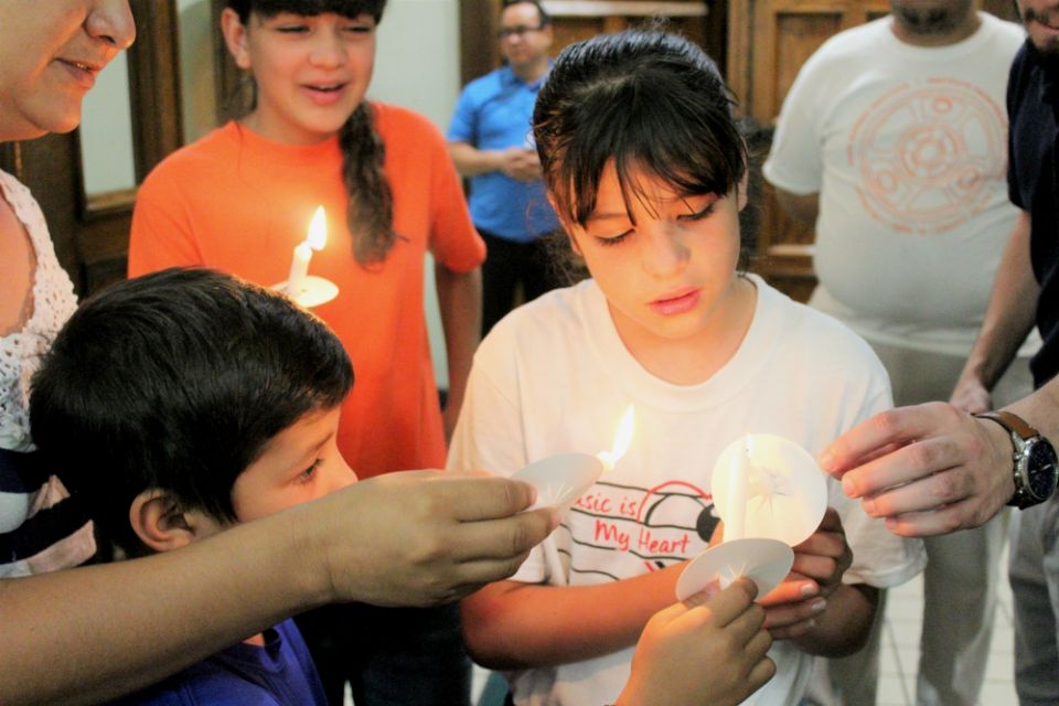 Guided by parents, children light candles during the July 20 service at St. Patrick Cathedral in El Paso, Texas. (MVO Photography/Lulu Olvera)