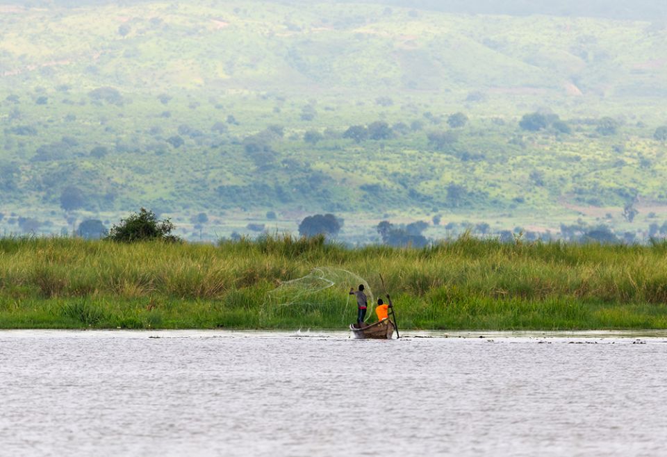 Two fishermen throw a net out on Lake Albert in Uganda. (Dreamstime/Mathias Sunke)