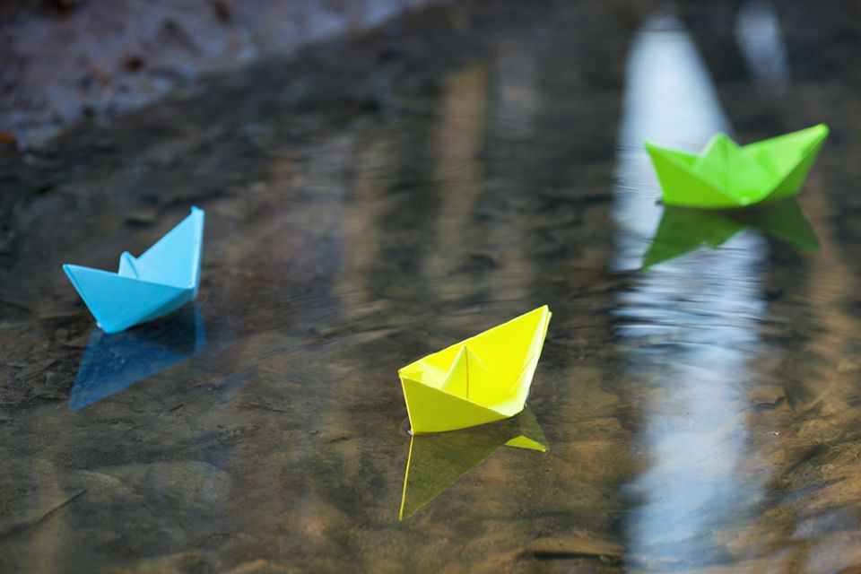 Paper boats in shallow water (Dreamstime/Gyso4ka)