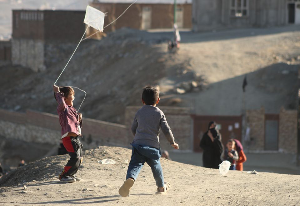 Children fly a kite in Afghanistan. (Unsplash/Farid Ershad)