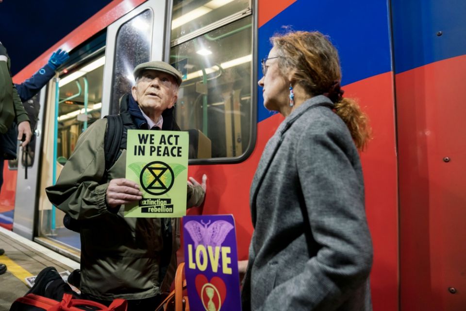Phil Kingston, 83, a former parole officer, protests climate change after super-gluing himself to the side of a train on the platform at London's Shadwell Station Oct. 17. (Courtesy of Extinction Rebellion/ Vladimir Morozov) Phil Kingston, 83, a former parole officer, protests climate change after super-gluing himself to the side of a train on the platform at London's Shadwell Station Oct. 17. (Courtesy of Extinction Rebellion/ Vladimir Morozov)