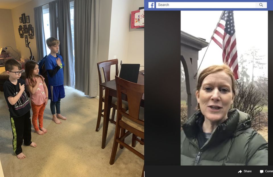 Jaxon, Avri and Brayden, students at Holy Family Catholic Academy, stand for the Pledge of Allegiance in their dining room and watch on a tablet their principal Catherine O'Brien (left) lead the school via Facebook Live outside her own home.
