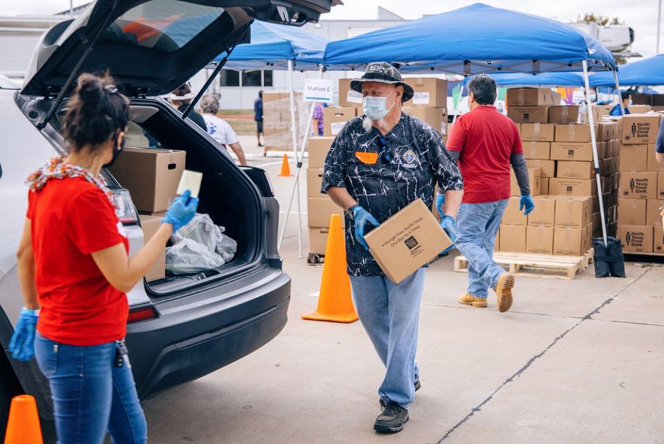 Staff with Catholic Charities Dallas load boxes of food into cars of families at a distribution center in July 2020. (Courtesy of Catholic Charities Dallas) Staff with Catholic Charities Dallas load boxes of food into cars of families at a distribution center in July 2020. (Courtesy of Catholic Charities Dallas)