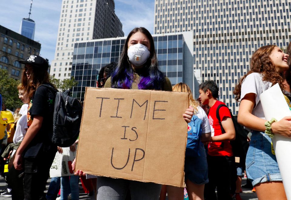A young woman wears an air-filtering mask and holds a sign while participating in the Global Climate Strike in New York City in September 2019. (CNS photo/Gregory A. Shemitz) 