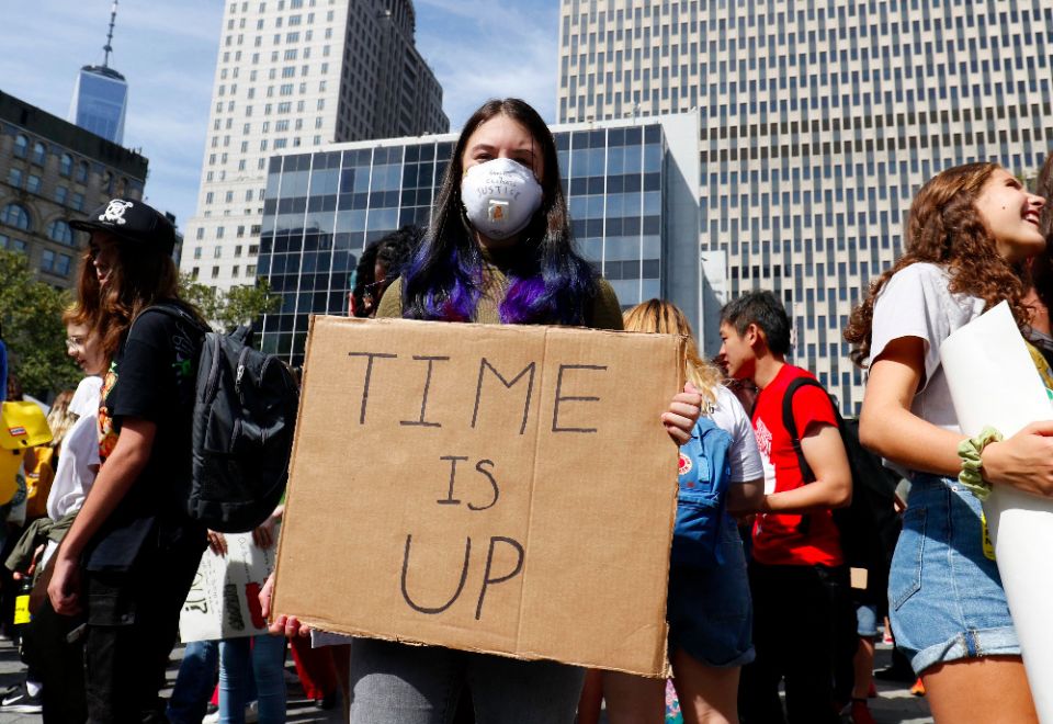 A young woman wears an air-filtering mask and holds a sign while participating in the Global Climate Strike in New York City in September 2019. (CNS photo/Gregory A. Shemitz)