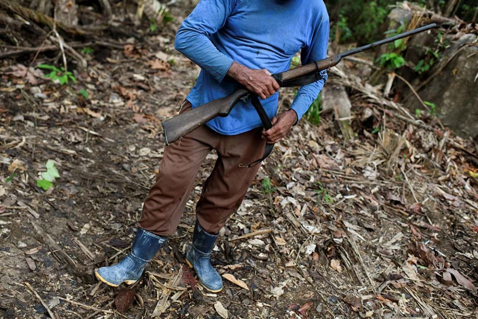 A miner poses with a shotgun at an illegal gold mine within an environmental preservation area in the Amazon rainforest, in Itaituba, Pará state, Brazil, Sept. 5. (Newscom/Reuters/Lucas Landau)