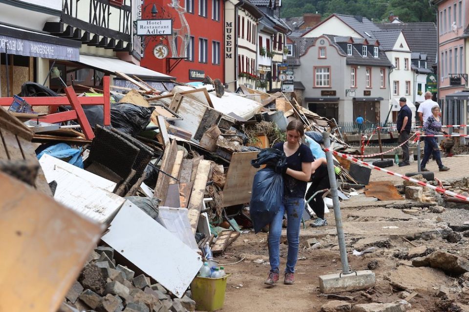 People walk through an area affected by flooding in Bad Münstereifel, Germany, July 19. Nearly 200 people have been confirmed dead, while dozens of others remain missing. (CNS photo/Wolfgang Rattay, Reuters)