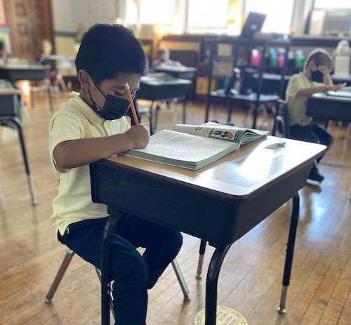 A student at St. Joseph the Worker Catholic Academy in Brooklyn, New York, writes in a workbook. (Courtesy of St. Joseph the Worker Catholic Academy)