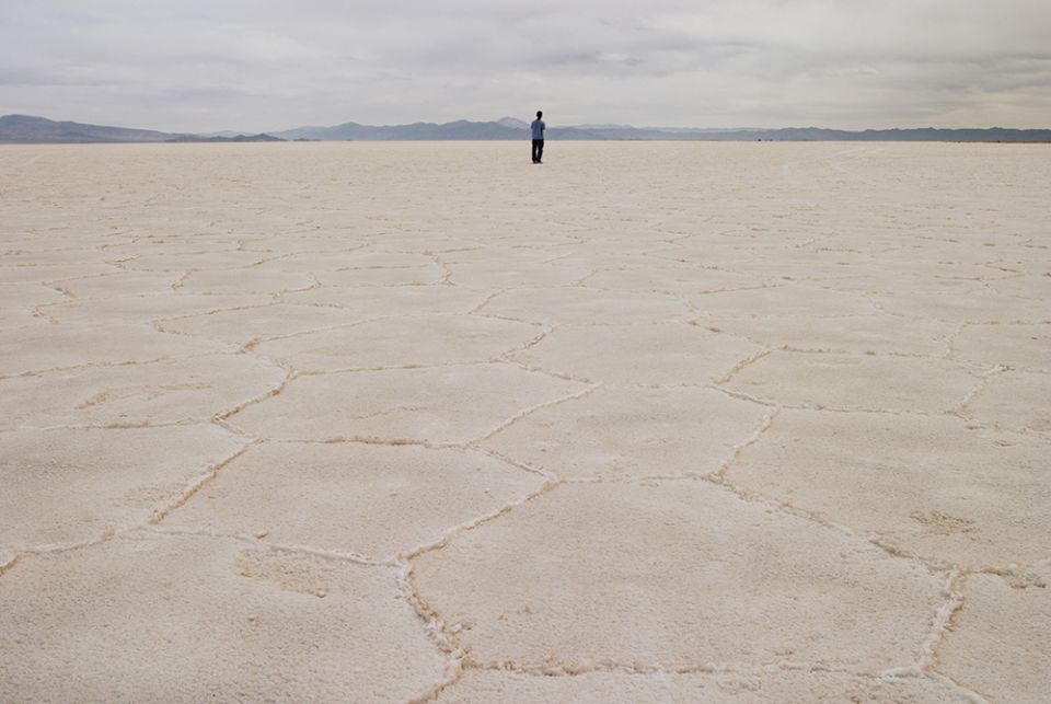 A person stands on the salt flat Salar de Arizaro, in Salta province, Argentina. In Salta and Jujuy provinces, Indigenous communities, whose livelihood depends on the extraction of salt from great deposits, oppose lithium mining, which directly impacts th A person stands on the salt flat Salar de Arizaro, in Salta province, Argentina. In Salta and Jujuy provinces, Indigenous communities, whose livelihood depends on the extraction of salt from great deposits, oppose lithium mining, which directly impacts th