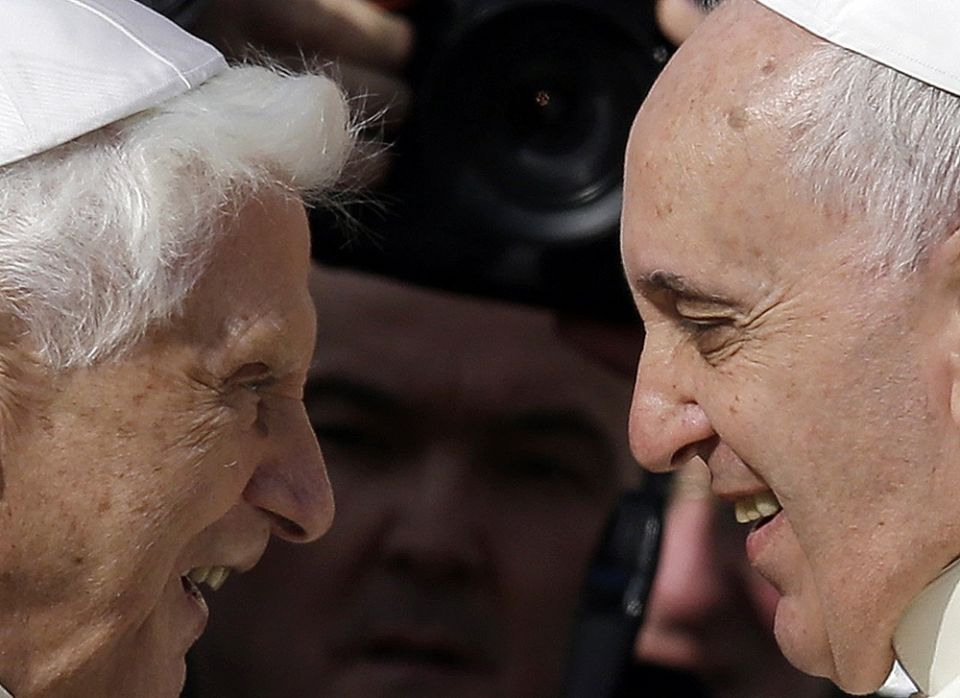 Pope Francis greets Pope Emeritus Benedict XVI prior to the start of a meeting with elderly faithful in St. Peter's Square at the Vatican, on Sept. 28, 2014.