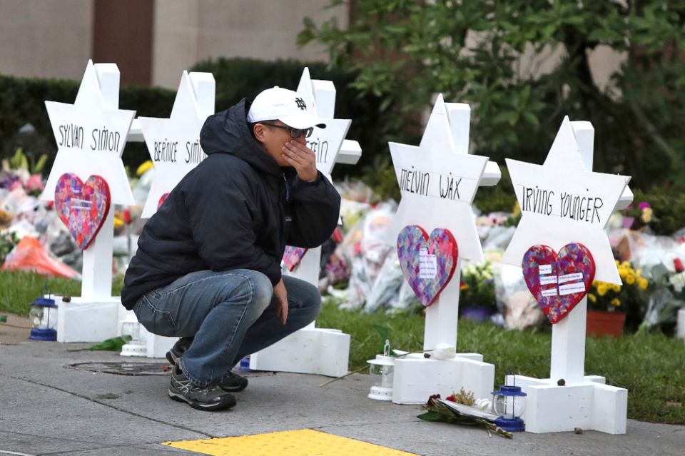 A young man reacts Oct. 29, 2018, at a makeshift memorial outside the Tree of Life synagogue in Pittsburgh. (CNS/Reuters/Cathal McNaughton) 