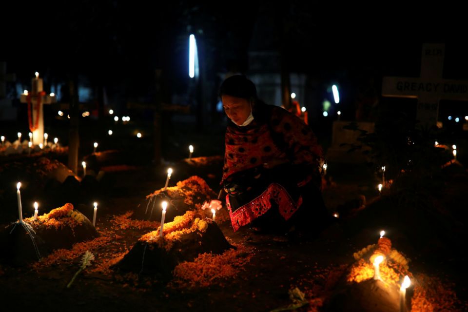 A Christian woman lights candles on her relative’s grave during the observance of All Souls’ Day Nov. 2, 2019, in Dhaka, Bangladesh. (CNS/Reuters/Mohammad Ponir Hossain)