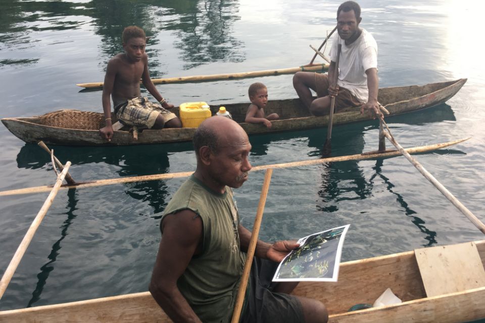 Fishers in Papua New Guinea look at Planet satellite reef imagery for local reefs. (Courtesy of Chris Roelfsema)