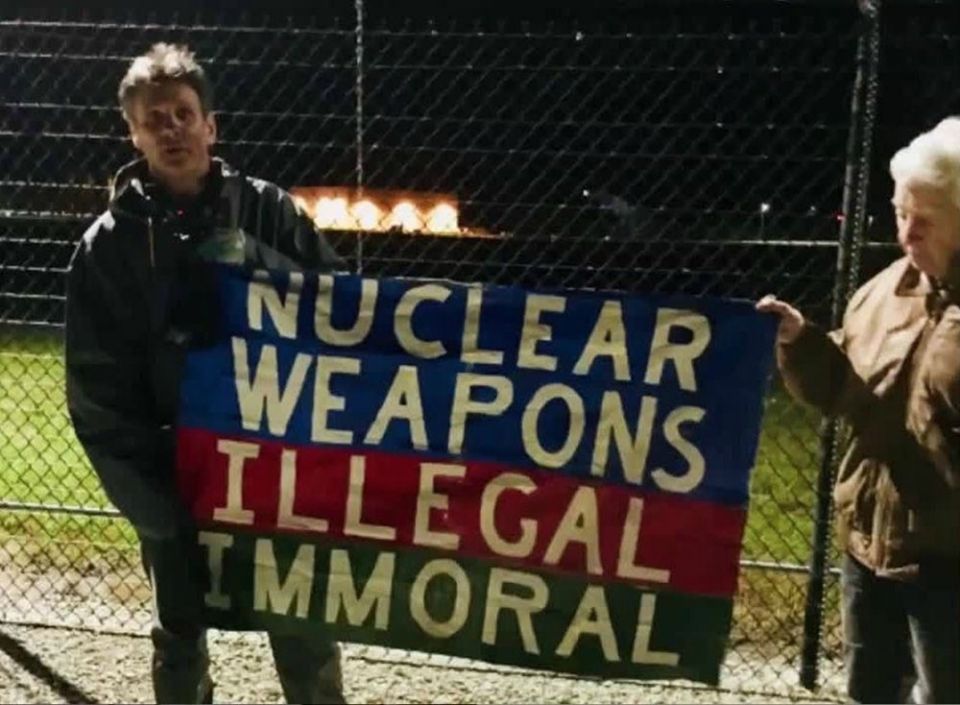Carmen Trotta, left, and Elizabeth McAlister hold a sign while entering the Kings Bay Naval Submarine Base in St. Marys, Georgia. (RNS/Courtesy of the Kings Bay Plowshares 7) Carmen Trotta, left, and Elizabeth McAlister hold a sign while entering the Kings Bay Naval Submarine Base in St. Marys, Georgia. (RNS/Courtesy of the Kings Bay Plowshares 7)
