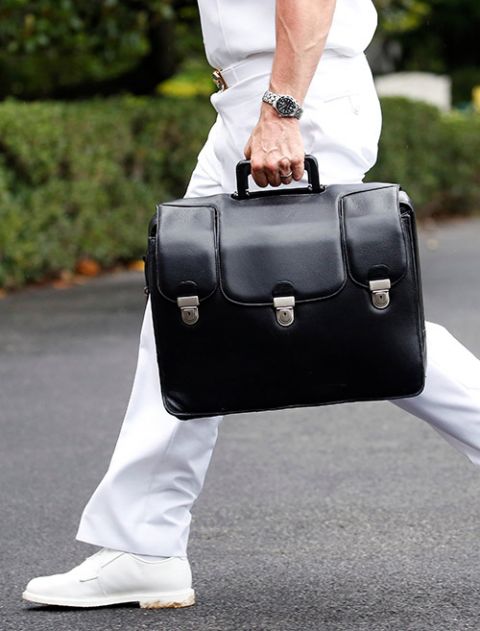 A military aide carries a briefcase containing launch codes for nuclear weapons as then-President Donald Trump returns to the White House in Washington in July 2018. (CNS/Reuters/Joshua Roberts)