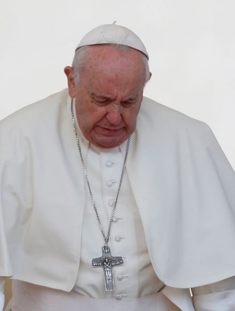 Pope Francis grimaces in pain as he gets up from his chair during the general audience in St. Peter's Square at the Vatican April 20. The pope told the Argentine newspaper La Nación his limited mobility and pronounced limp are due to a torn ligament. 