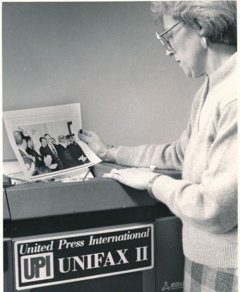 Barbara Stephenson, entonces editora de fotos de Catholic News Service, recibe una imagen de la máquina "Unifax II" de United Press International en esta foto de archivo de 1990. (CNS)