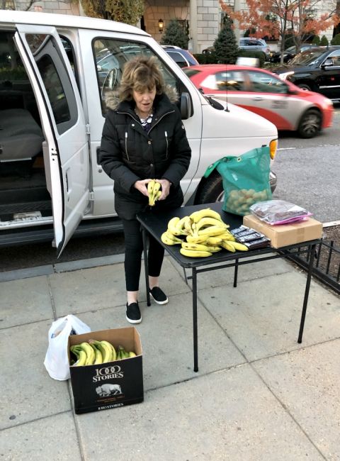 A woman helps set up a fruit and dessert station for the homeless. (Jack McHale)
