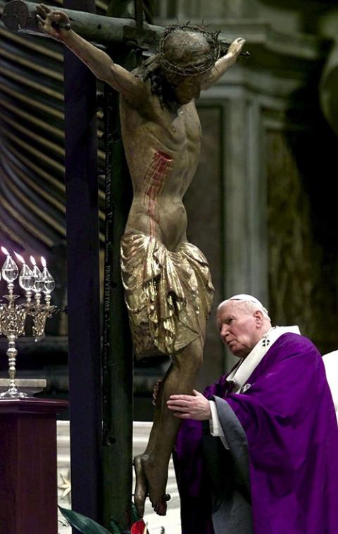 Pope John Paul II embraces the crucifix in St. Peter's Basilica at the Vatican March 13, 2000, during a liturgy in which he asked forgiveness for past and present sins of Christians. (CNS/Reuters)