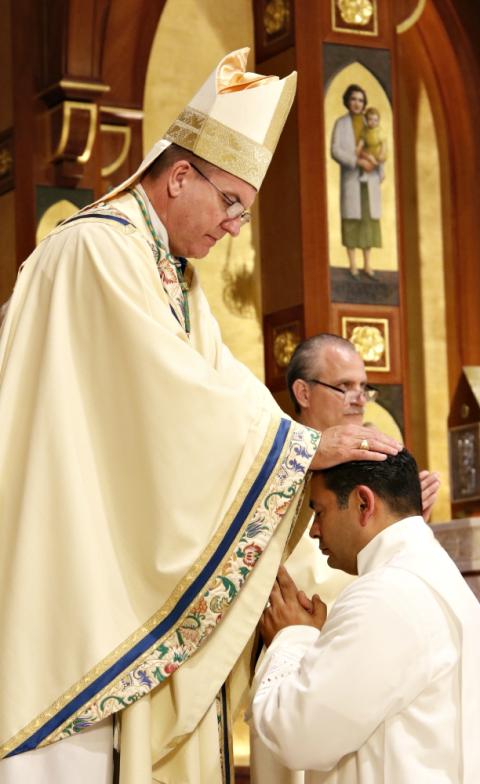 Bishop John Barres of Rockville Centre, New York, lays hands on Deacon Ralph Colon during the ordination of permanent deacons June 3 at St. Agnes Cathedral in Rockville Centre. (CNS/Gregory A. Shemitz)