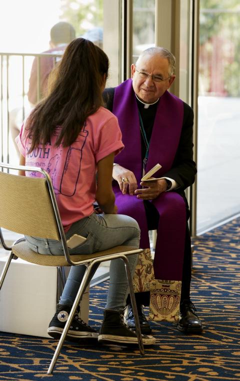 Archbishop José Gomez hears confession Aug. 4 during the third annual City of Saints youth conference on the campus of University of California, Los Angeles. (CNS/Angelus News/Victor Aleman)