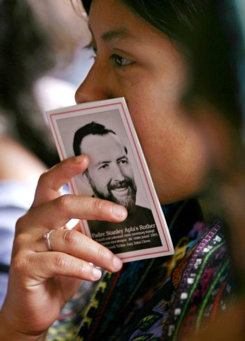 A woman holds a booklet with a picture of Fr. Stanley Rother during Mass in 2006 at a church in Santiago Atitlán, Guatemala. (CNS/Reuters/Daniel LeClair)