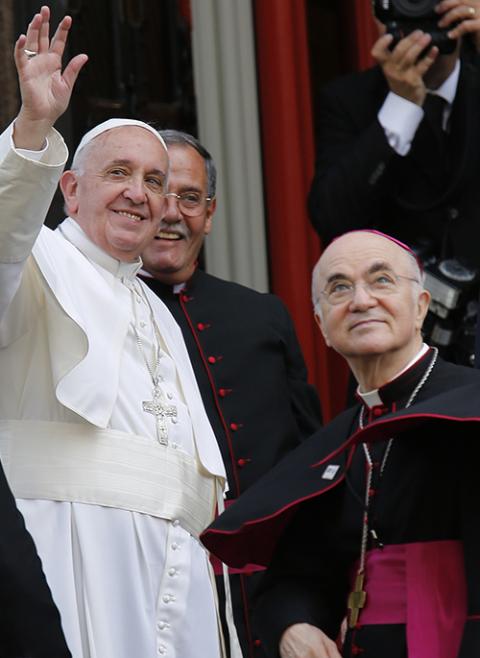 Pope Francis in 2015 waves alongside Archbishop Carlo Maria Vigano, then the apostolic nuncio to the United States, right, outside St. Patrick in the City Church in Washington. (CNS/Bob Roller) Pope Francis in 2015 waves alongside Archbishop Carlo Maria Vigano, then the apostolic nuncio to the United States, right, outside St. Patrick in the City Church in Washington. (CNS/Bob Roller)
