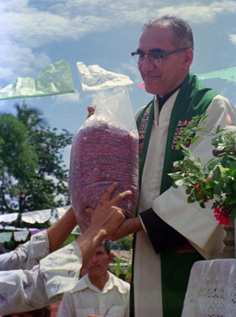 Then-Archbishop Oscar Romero receives a sack of beans from parishioners following Mass outside of a church in San Antonio Los Ranchos in Chalatenango, El Salvador, in 1979. (CNS/Octavio Duran)
