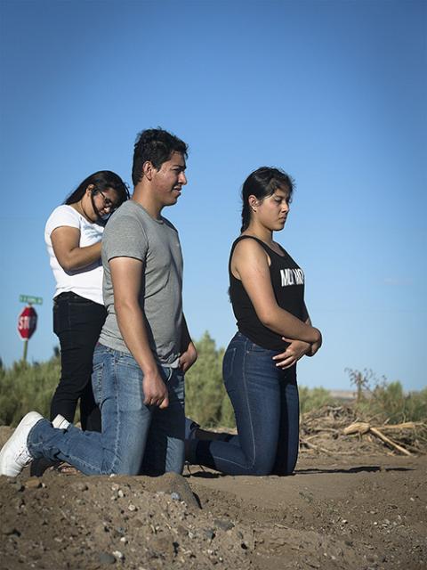 Migrant farmworkers kneel in prayer during an outdoor Mass Sept. 26, 2019, in Hatch, New Mexico, part of a pastoral encounter by U.S. bishops with migrants at the border. (CNS/Tyler Orsburn)