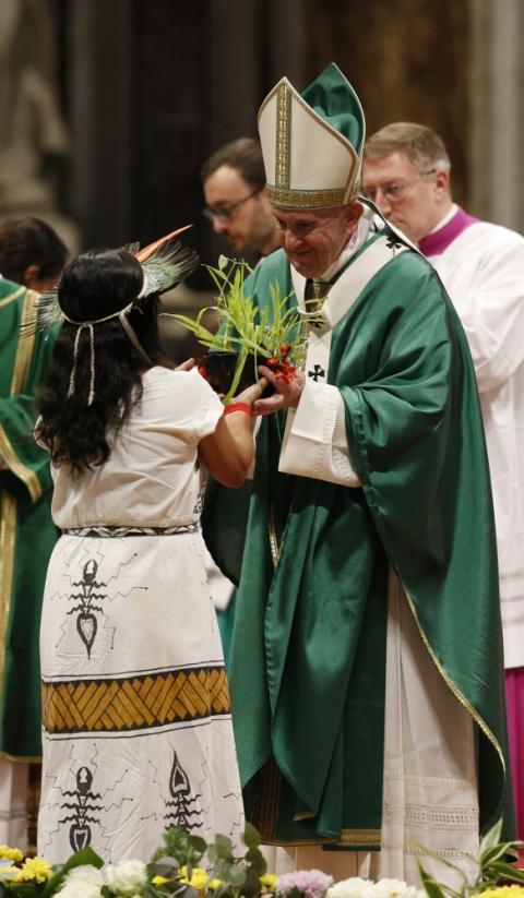 Pope Francis accepts a plant during the offertory as he celebrates the concluding Mass of the Synod of Bishops for the Amazon at the Vatican Oct. 27. (CNS/Paul Haring)
