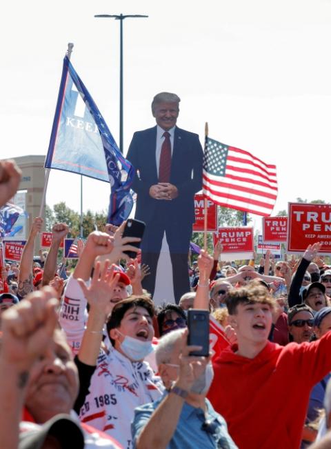 An image of President Donald Trump, who was being treated for COVID-19, is held aloft among supporters during a New York "Triumph Rally" on Staten Island in New York City Oct. 3. (CNS/Reuters/Andrew Kelly)