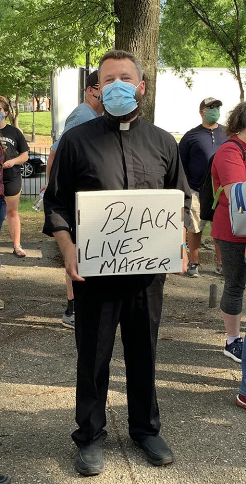 Fr. Joshua Laws, pastor of the Catholic Community of South Baltimore, holds a "Black Lives Matter" sign before the start of an interfaith prayer vigil in Baltimore June 3, 2020. (CNS/Catholic Review/Tim Swift) Fr. Joshua Laws, pastor of the Catholic Community of South Baltimore, holds a "Black Lives Matter" sign before the start of an interfaith prayer vigil in Baltimore June 3, 2020. (CNS/Catholic Review/Tim Swift)