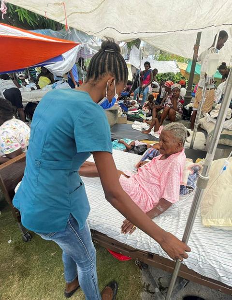 A woman is assisted by a member of the medical personnel outside a hospital in Les Cayes, Haiti, Aug. 16, following a magnitude 7.2 earthquake two days earlier. (CNS/Reuters/Ricardo Arduengo)