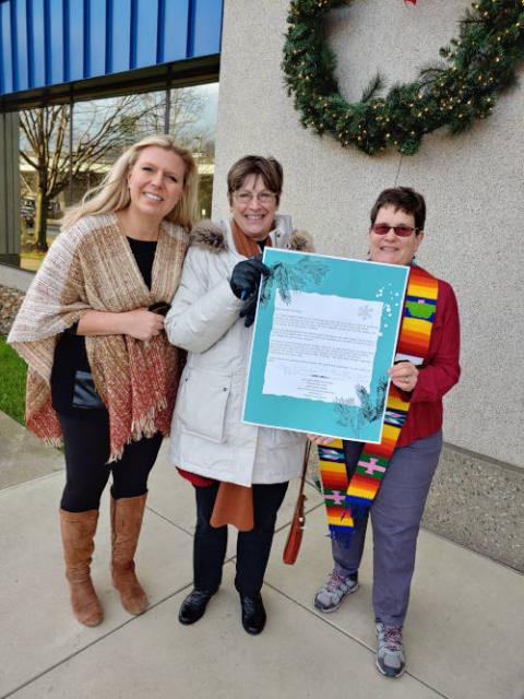 Members of West Virginia Interfaith Power & Light deliver a Christmas card Dec. 22 to Sen. Joe Manchin's office in Charleston, West Virginia, urging that he reconsider his opposition to the Build Back Better Act. (West Virginia Interfaith Power & Light)