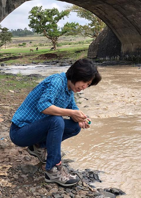 Shuang-Ye Wu of the University of Dayton Department of Geology samples river water as part of a 2019 study of groundwater in southwest Ohio. (Courtesy of University of Dayton)