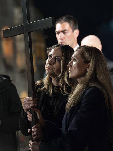 Ukrainian nurse Iryna and Russian nursing student Albina hold a cross at the 13th station as Pope Francis leads the Way of the Cross outside the Colosseum in Rome April 15. (CNS/Vatican Media)