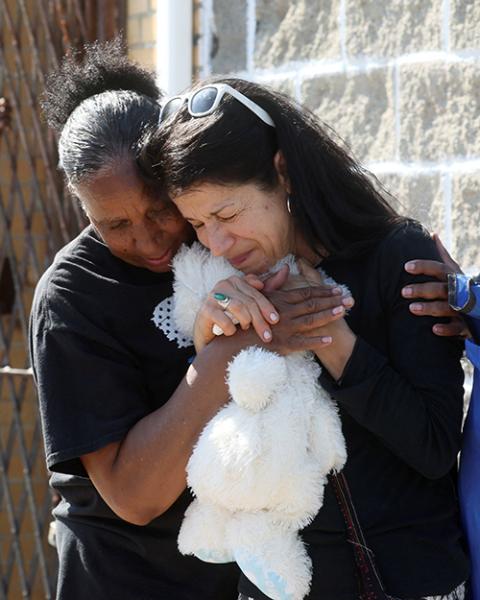 Mourners in Buffalo, New York, react May 15, while attending a vigil for victims of the shooting the day before at a TOPS supermarket. Authorities say the mass shooting that left 10 people dead was racially motivated. (CNS/Reuters/Brendan McDermid)