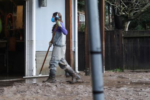 A resident cleans up mud that was left by receding floodwaters in Felton, Calif., Jan. 9, 2023.