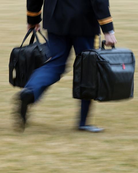 A White House military aide carries the so-called nuclear football as he walks to board the Marine One helicopter with President Joe Biden at the White House in Washington Feb. 16, 2021. (CNS/Reuters/Jonathan Ernst)