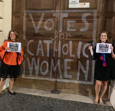 Deborah Rose-Milavec, left, and Kate McElwee pose in front of the doors of the Congregation for the Doctrine of the Faith at the Vatican with a projection saying, "Votes for Catholic Women," during the 2019 Synod of Bishops for the Amazon. (Provided photo)