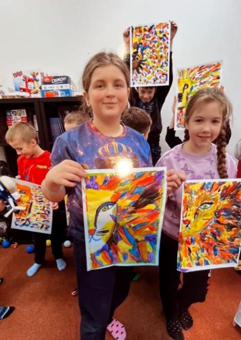  Refugee children from Ukraine show off their drawings after art therapy sessions offered by Caritas in Warsaw. (Peter Daly)