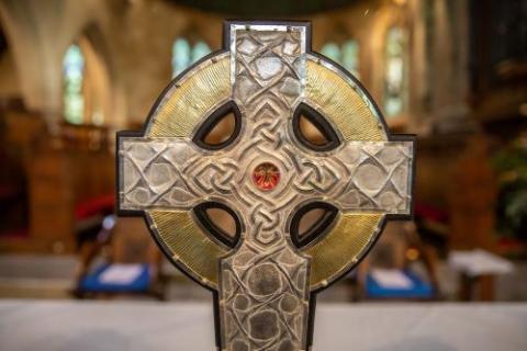 The top of the processional cross that will be used at the coronation of King Charles III in May is seen on the altar of an Anglican parish in Llandudo, Wales, April 19, 2023. Relics of Christ's cross, a gift from Pope Francis, are under glass in the center of the processional cross. (CNS/Dave Custance, courtesy of the Church in Wales)