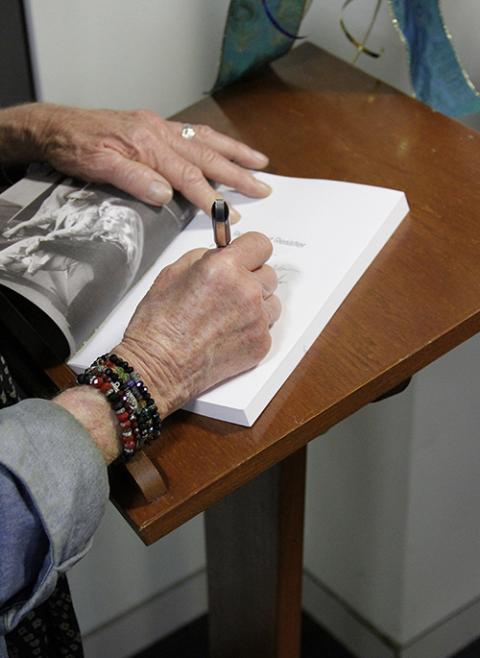 Jeff Dietrich, a member of the LA Catholic Worker community, signs a 40th anniversary edition of his book Reluctant Resister during an event at Loyola Marymount University (Courtesy of Los Angeles Catholic Worker)