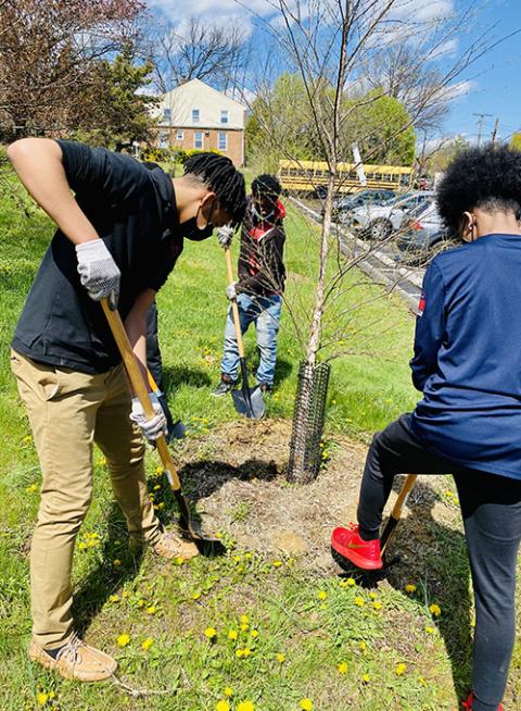 Students at St. Thomas More Academy in Washington, D.C., take part in a spring service project to clean and prepare tree beds around their school in April 2022. (St. Thomas More Academy/Gerald Smith)