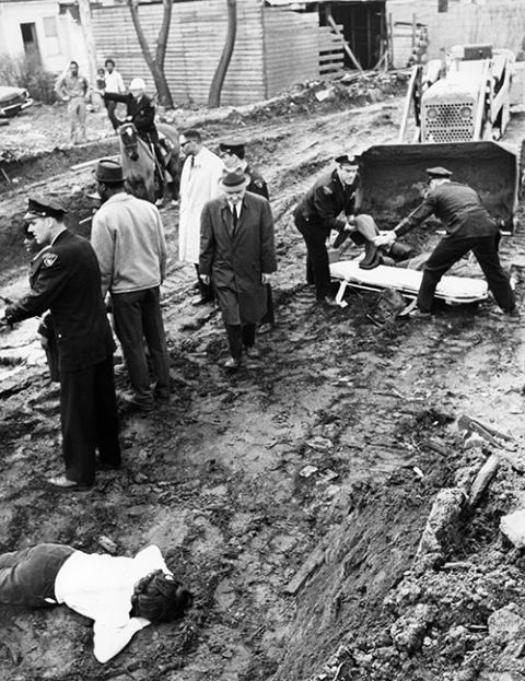 An unidentified civil rights demonstrator lies uninjured on the ground in Cleveland on April 7, 1964, while police prepare to place the body of the Rev. Bruce Klunder on a stretcher. Klunder, one of the demonstrators, was killed when a tractor ran over him. (AP/Julian C. Wilson)