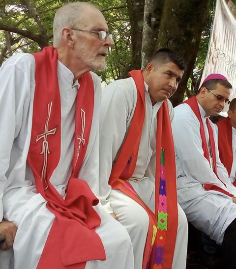 Franciscan Fr. Brendan Forde, left, listens during Mass May 14, 2019, with members of the Diocese of Chalatenango at the site of a massacre in an area known as Las Aradas in northern El Salvador. Forde, an Irish missionary friar who lived through some of the most turbulent conflicts of 20th-century Latin America, died July 8 in his native Ireland. (NCR photo/Courtesy of Diocese of Chalatenango/Roberto Rivas)